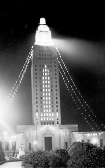 The tower light in the Louisiana State Capitol shines on the statue of Huey Long.
