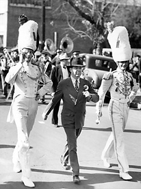 Huey Long marches with the Louisiana State University band. Long's first step to generate excitement for LSU was to quadruple the size of the marching band.